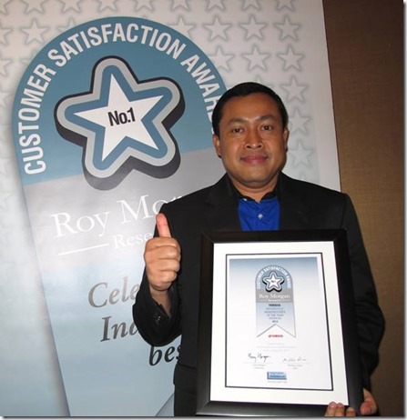 Direktur Sales Yamaha Indonesia Sutarya dengan piagam penghargaan Roy Morgan Award