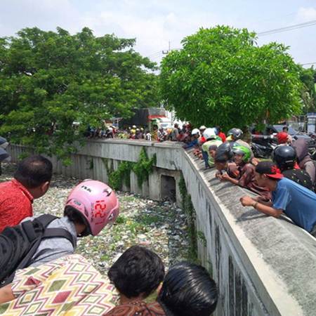 Hindari Razia Lalu lintas, Seorang Pengendara Motor Nekat terjun ke Sungai Penuh Sampah Di Surabaya